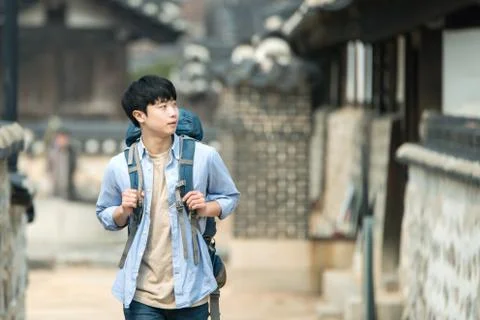 A young man doing a backpacking trip in a Korean traditional house. Stock Photos
