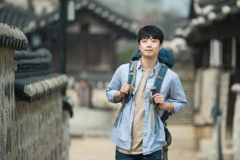 A young man doing a backpacking trip in a Korean traditional house. Stock Photos