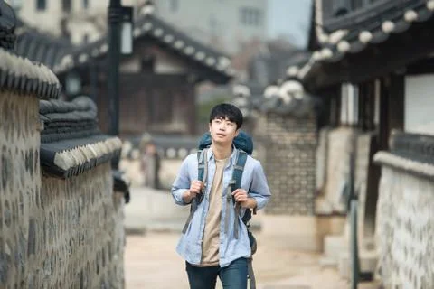 A young man doing a backpacking trip in a Korean traditional house. Stock Photos