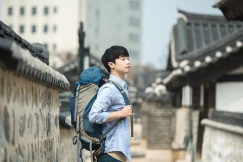 A young man doing a backpacking trip in a Korean traditional house. Stock Photos
