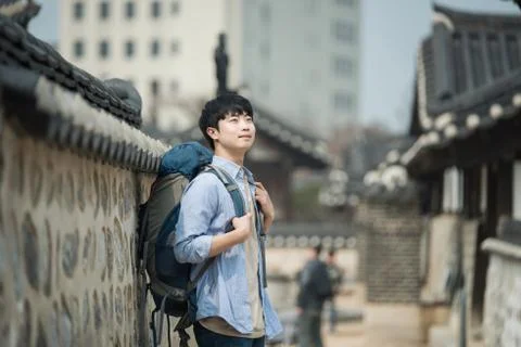 A young man doing a backpacking trip in a Korean traditional house. Stock Photos
