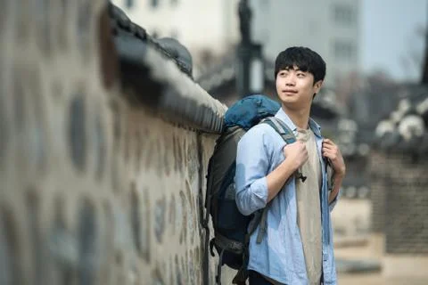 A young man doing a backpacking trip in a Korean traditional house. Stock Photos