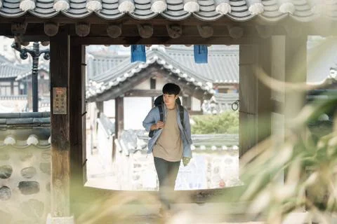 A young man doing a backpacking trip in a Korean traditional house. Stock Photos