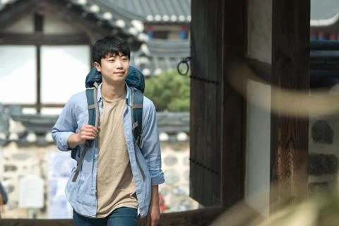A young man doing a backpacking trip in a Korean traditional house. Stock Photos