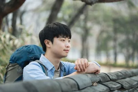 A young man doing a backpacking trip in a Korean traditional house. Stock Photos