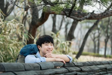 A young man doing a backpacking trip in a Korean traditional house. Stock Photos