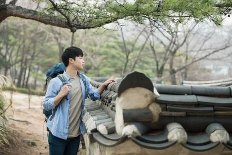 A young man doing a backpacking trip in a Korean traditional house. Stock Photos