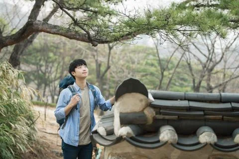 A young man doing a backpacking trip in a Korean traditional house. Stock Photos