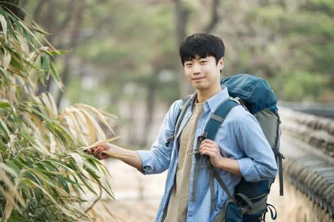 A young man doing a backpacking trip in a Korean traditional house. Stock Photos