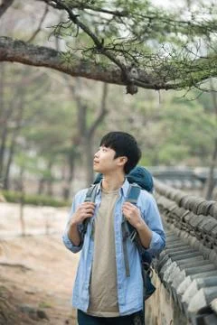 A young man doing a backpacking trip in a Korean traditional house. Stock Photos
