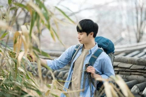 A young man doing a backpacking trip in a Korean traditional house. Stock Photos