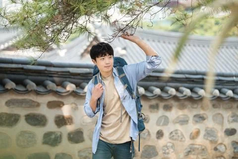 A young man doing a backpacking trip in a Korean traditional house. Stock Photos