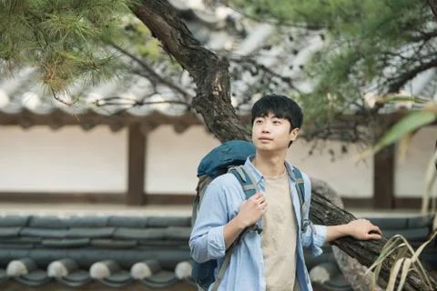 A young man doing a backpacking trip in a Korean traditional house. Stock Photos