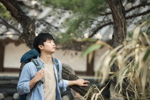 A young man doing a backpacking trip in a Korean traditional house. Stock Photos
