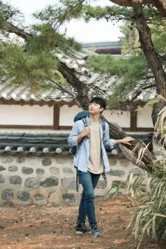 A young man doing a backpacking trip in a Korean traditional house. Stock Photos
