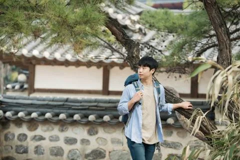 A young man doing a backpacking trip in a Korean traditional house. Stock Photos