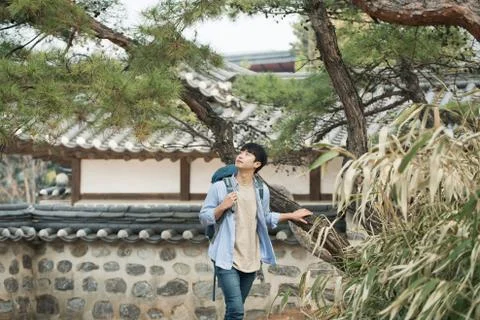 A young man doing a backpacking trip in a Korean traditional house. Stock Photos