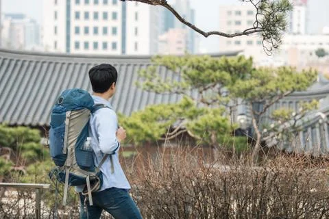 A young man doing a backpacking trip in a Korean traditional house. Stock Photos
