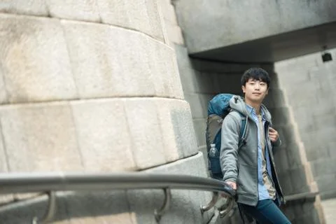 A young man doing a backpacking trip in a Korean traditional house. Stock Photos