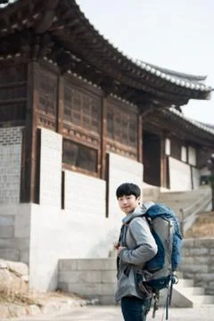 Young man doing a backpacking trip in a Korean traditional house. Selective f Stock Photos