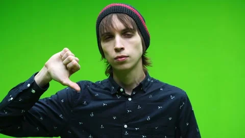 Young man doing bad symbol against a removable chroma key background Stock Footage 155585968