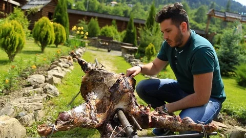 Young man doing barbecue in the mountains Stock Footage 98984397