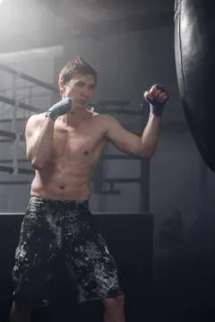 Young man doing boxing workout in the gym Stock Photos