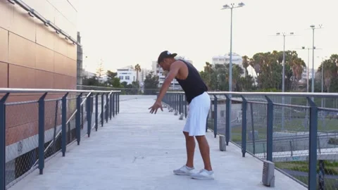 Young man doing breakdancing stunts in urban park Stock Footage 132070532