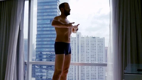 Young man doing breath exercise by the window at home, super slow motion Stock Footage 84385783