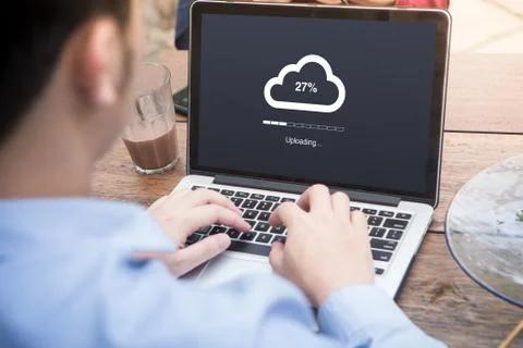 Young man doing cloud uploading using laptop / computer concept at the outdoor  Stock Photos