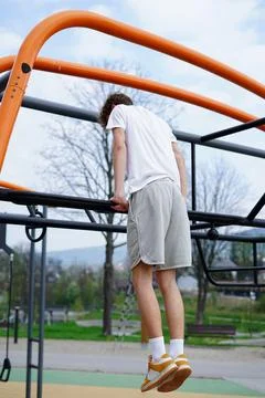 Young man doing dips on outdoor monkey bars Stock Photos
