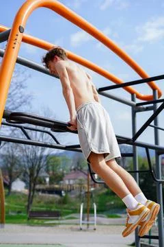 Young man doing dips on outdoor monkey bars Stock Photos