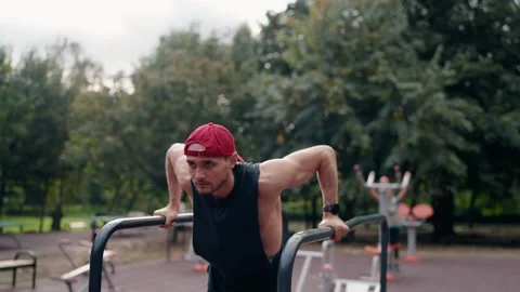 Young Man Doing Dips on Parallel Bars in an Outdoor Park Workout Stock Footage 307414454