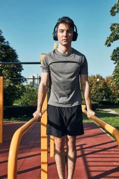 Young man doing dips on parallel bars during his workout in a modern calisthe Stock Photos