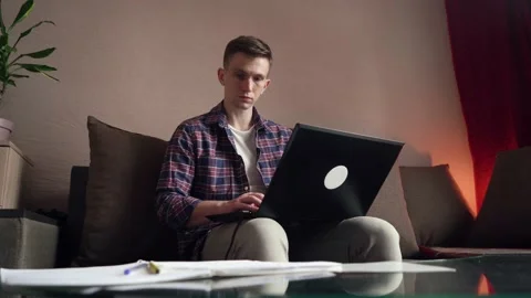 Young man is doing distance learning at home using a computer. coronavirus Stock Footage 211812708