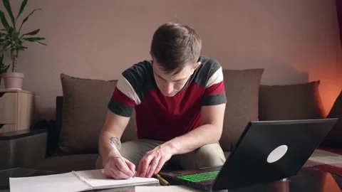 Young man is doing distance learning at home using a computer. coronavirus Stock-Footage 211812842