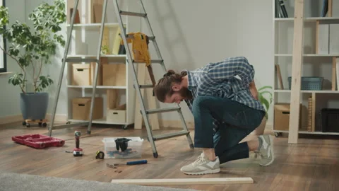 Young Man Doing DIY Repairs at Home Feeling Pain in his lower back. Video stock 262112574