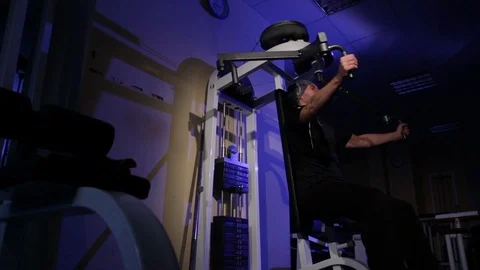 A young man is doing an exercise on the chest muscles on the simulator.copy Stock Footage 115248969