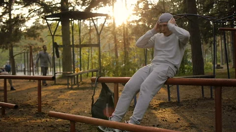 Young man doing exercise at the horizontal bar in the evening Stock Footage 64017139