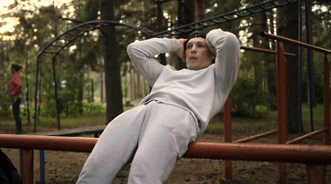 Young man doing exercise at the horizontal bar in the evening Stock Footage 64017299