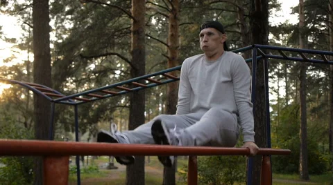 Young man doing exercise at the horizontal bar in the evening Stock Footage 64018167