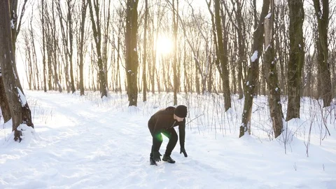 Young man doing exercise outdoors at winter while snowing at dusk Stock Footage 87920910