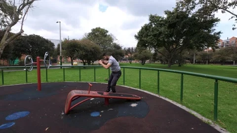 Young man doing an exercise routine outdoors in a park in the city Stock Footage 253593627