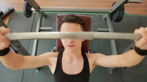 A young man doing exercises with a barbell Stock Footage 91941990