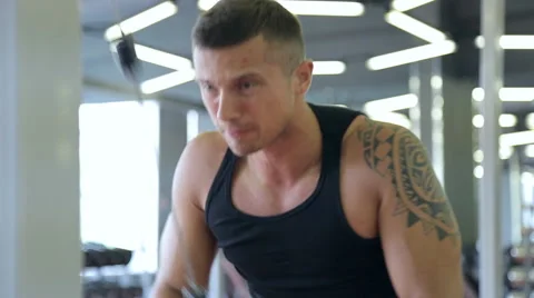 Young man doing exercises in a gym, workout Vidéo 66431852