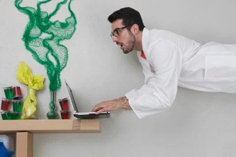 Young man doing experiment and using laptop 写真素材