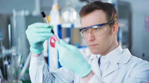 A young man doing an experiment in a chemical laboratory Video stock 85328192