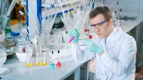 A young man doing an experiment in a chemical laboratory Stock Footage 85328324