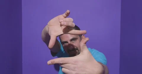 Young man doing frame using hands and fingers, isolated over purple background Stock-Footage 266911992