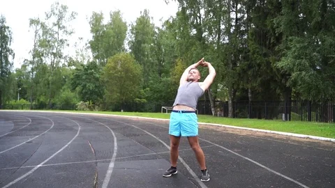Young man is doing a full body warm up Stock Footage 114089562